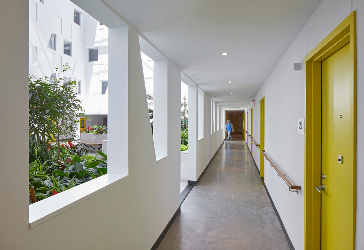 The residential facility is a courtyard building with corridors looking inward toward a central green public space.