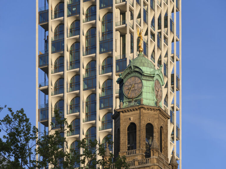 Façade of POST by ODA and Omnam Group behind the tower of Rotterdam’s former Central Post Office. Photo: Ossip van Duivenbode.