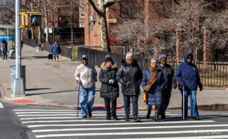 People walking across the street with winter coats on