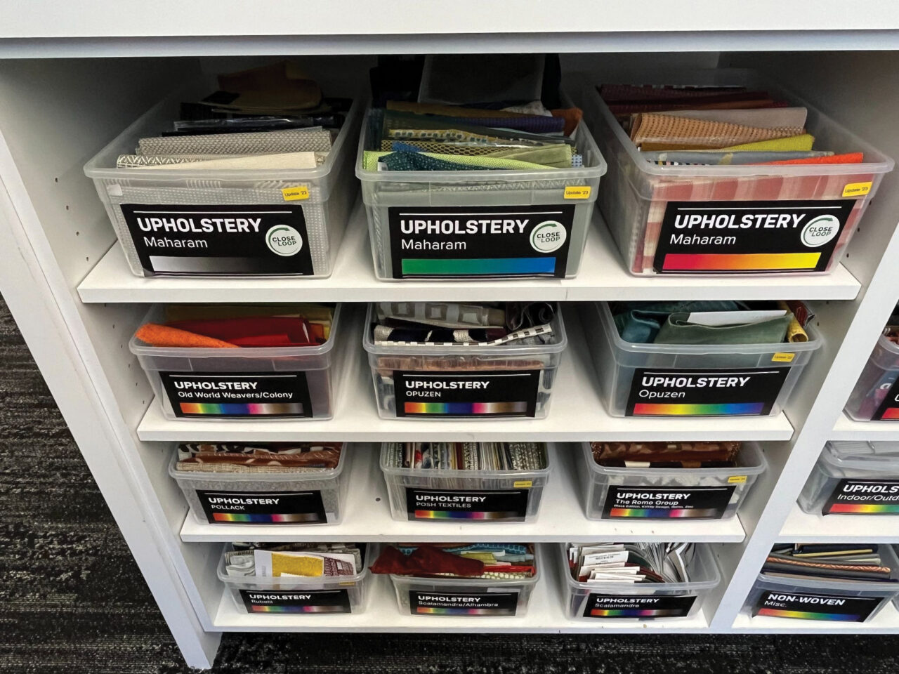 Several rows of shelves with plastic bins holding various upholstery samples