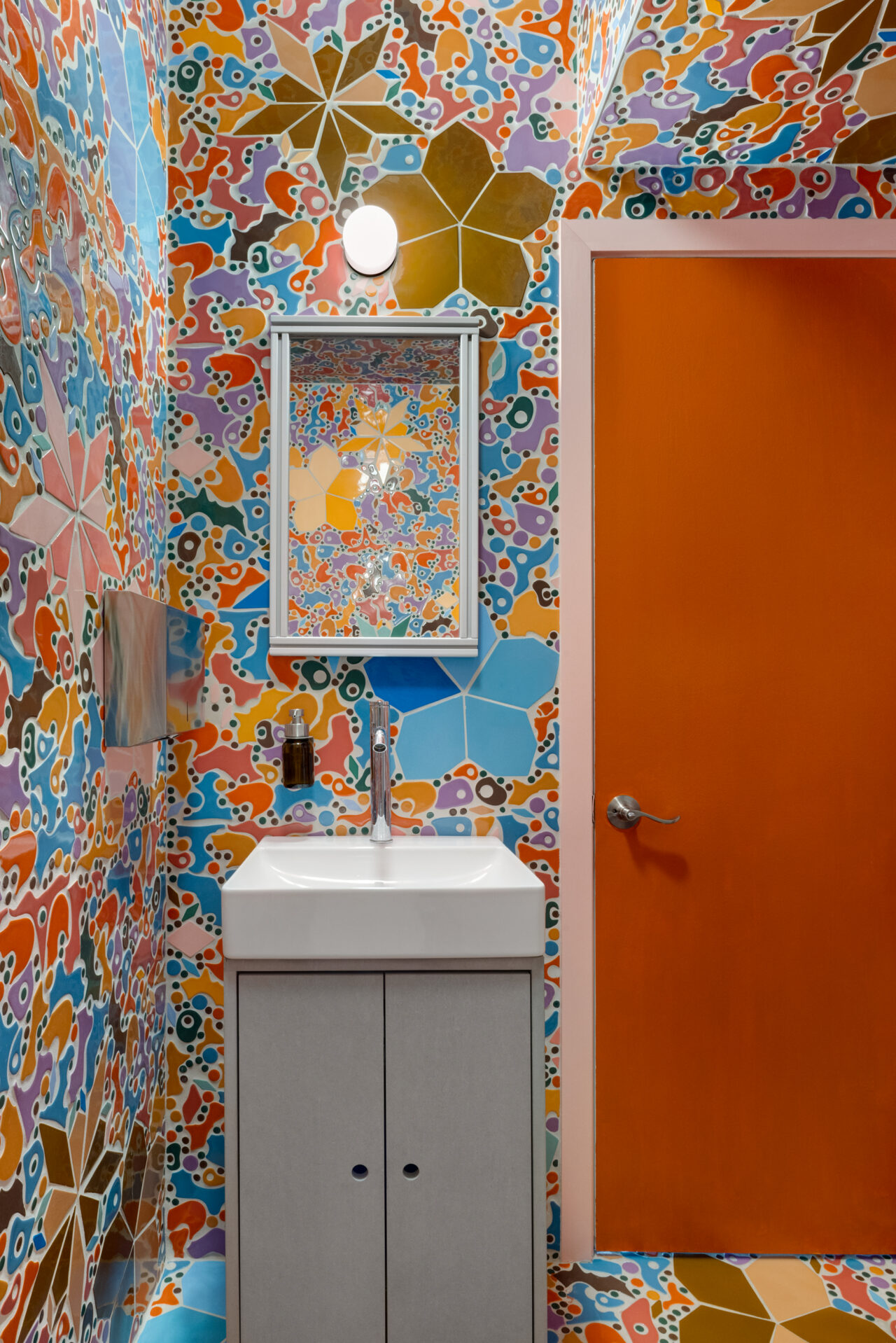 Colorful bathroom interior with colorful tile and and an orange door within the Storefront for Art and Architecture