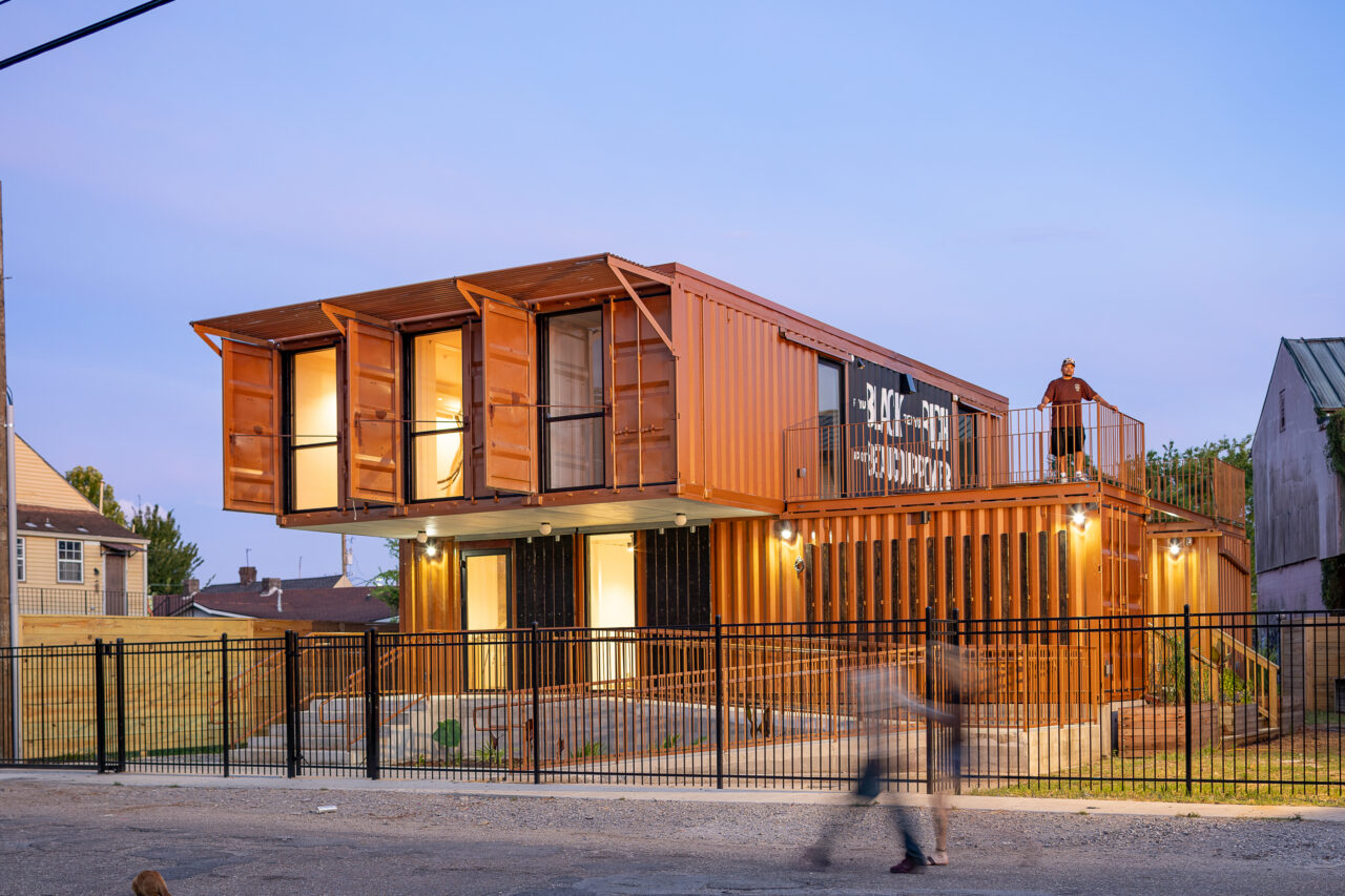 A closer view of the exterior facade of a school house with striking contemporary architecture that appears to made from corrugated shipping containers