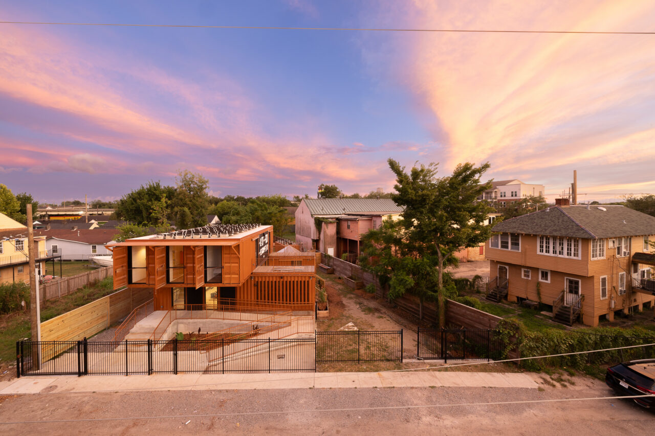 Exterior of a school house with striking contemporary architecture and its neighboring lots, seen from birds-eye view