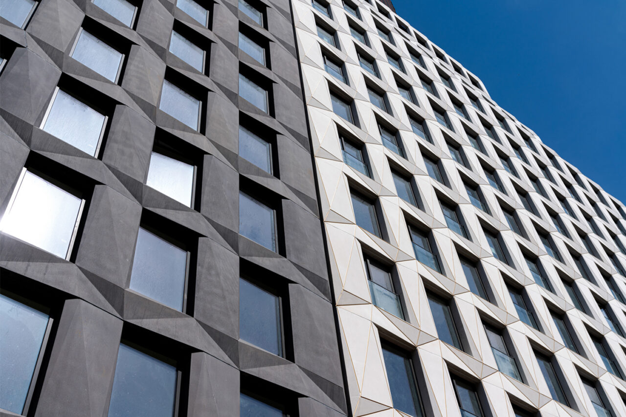 Closeup of a gray and light gray building facade with windows