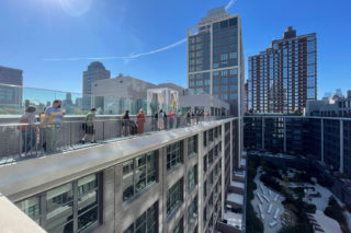 Group of people tour the rooftop of Front & York by Morris Adjmi Architects.