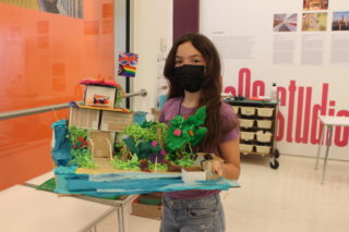 Student holding architecture model of a house
