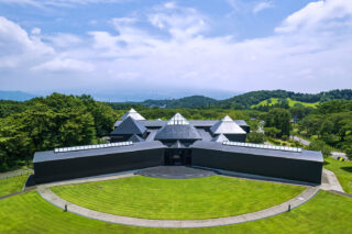 A bird's-eye view of a museum building surrounded by green grass